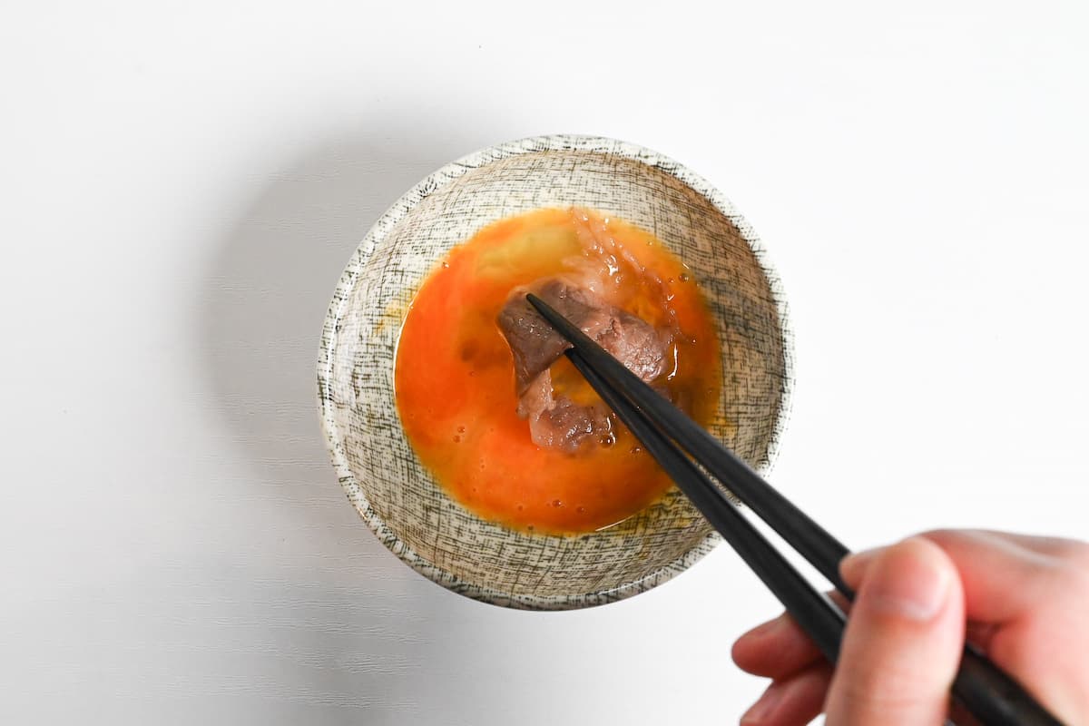 Dipping sukiyaki beef in whisked egg