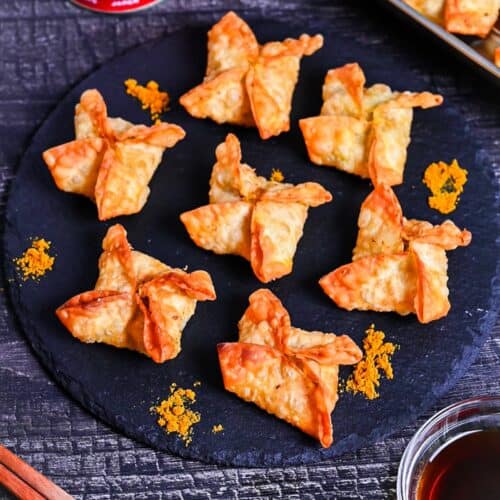 curry flavored age-gyoza (deep-fried gyoza) on a slate plate sprinkled with curry powder