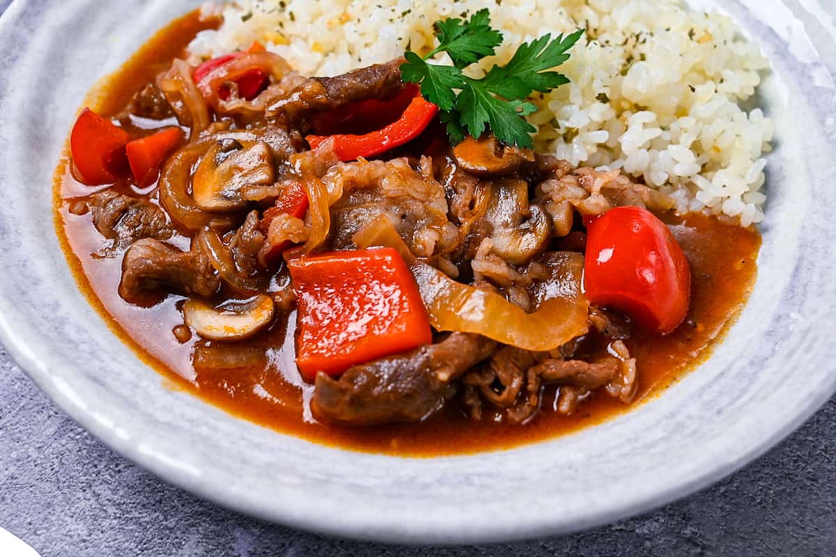 Japanese beef hayashi rice with garlic butter rice topped with fresh parsley close up