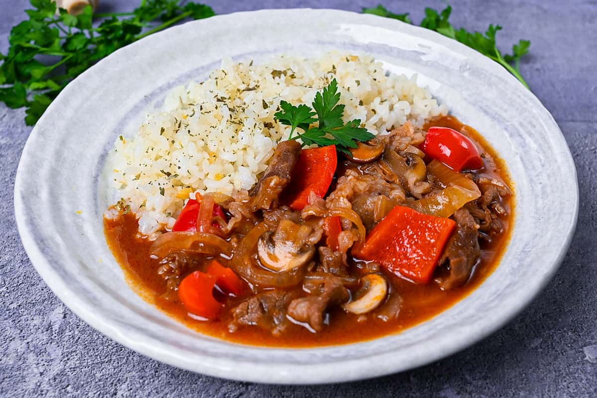 Japanese beef hayashi rice with garlic butter rice topped with fresh parsley side view