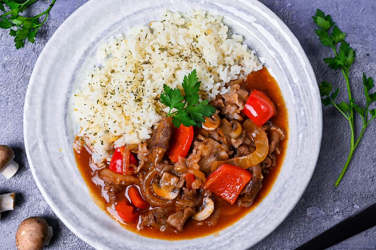 Japanese beef hayashi rice with garlic butter rice topped with fresh parsley top down landscape