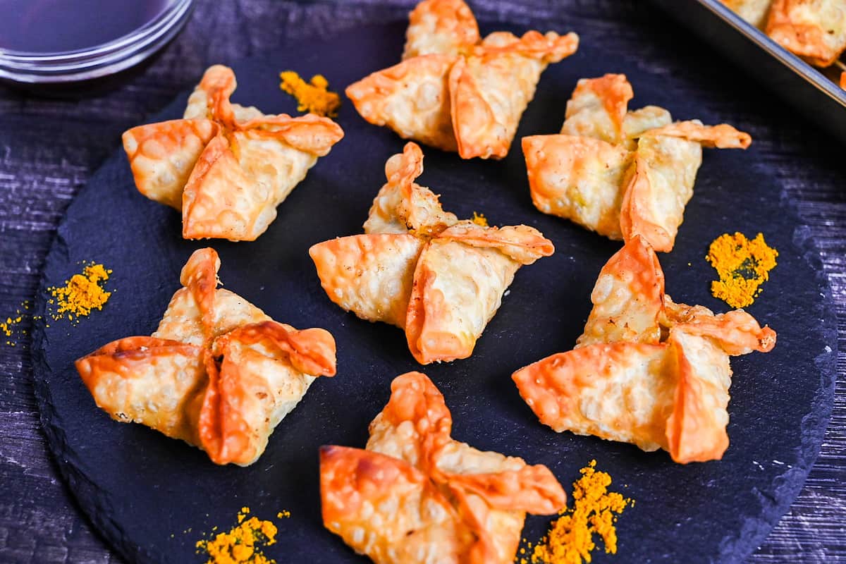 curry flavored age-gyoza (deep-fried gyoza) on a slate plate sprinkled with curry powder