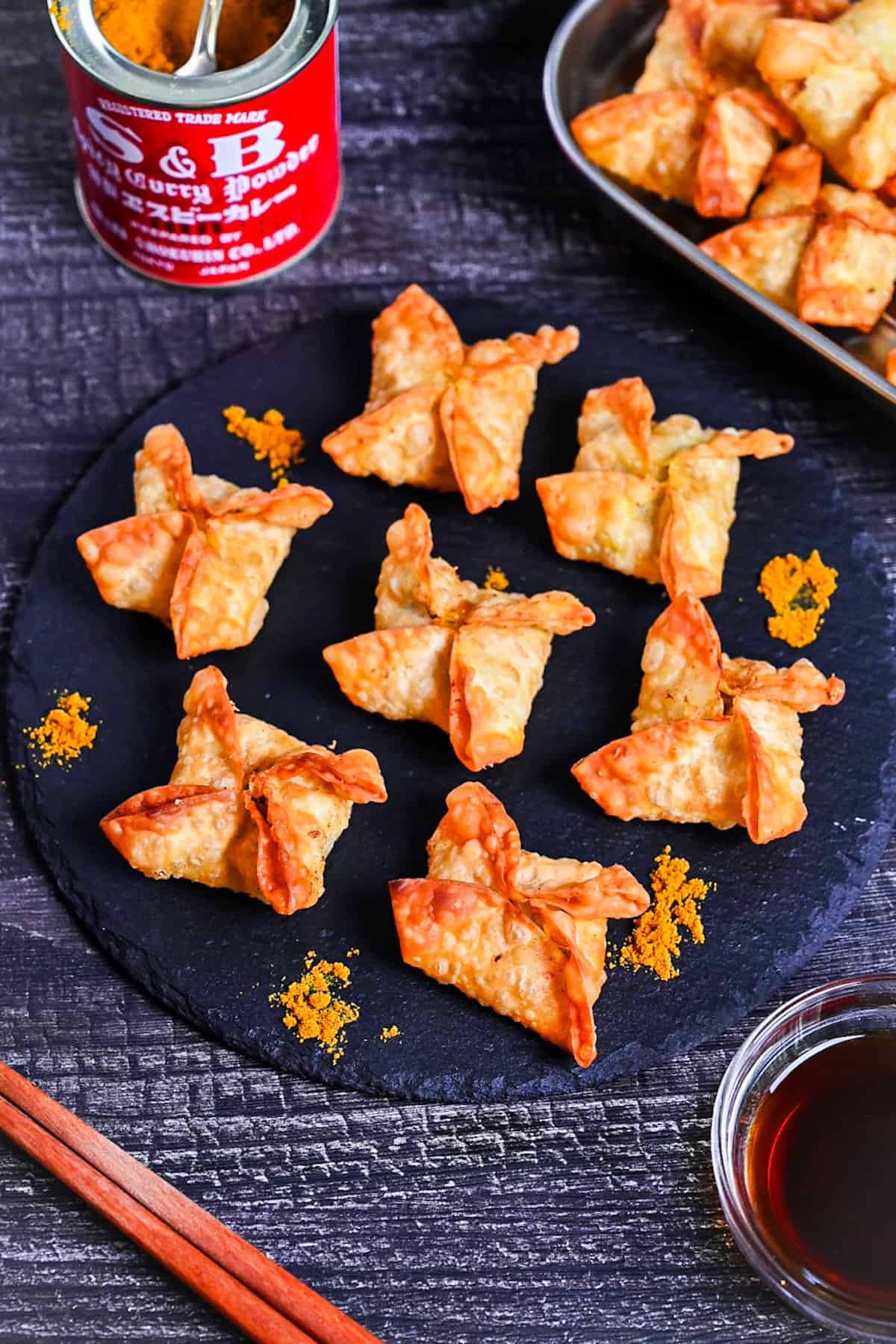 curry flavored age-gyoza (deep-fried gyoza) on a slate plate sprinkled with curry powder