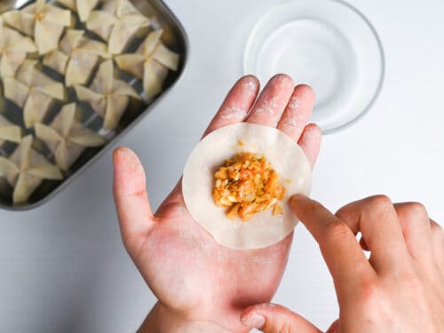 wetting the edge of gyoza wrapper with curry flavored filling