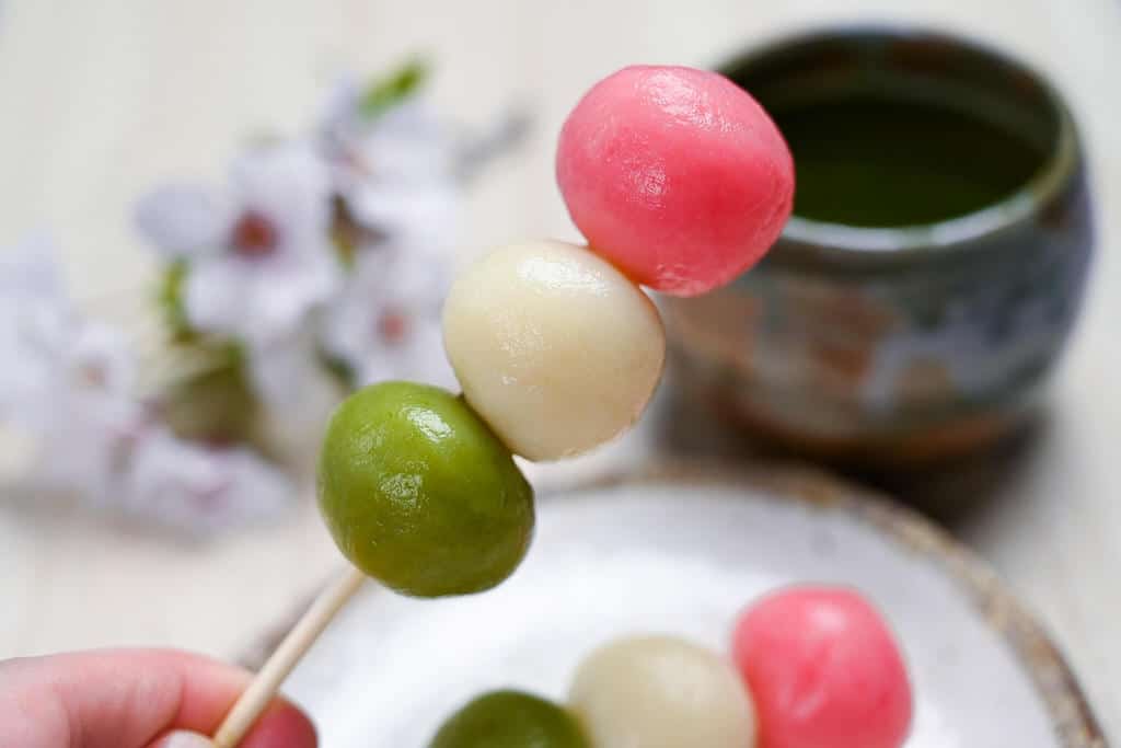 holding up one hanami dango skewer