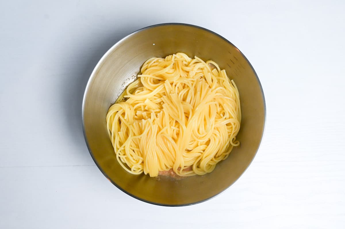 cooked spaghetti in a bowl on top of mentaiko sauce