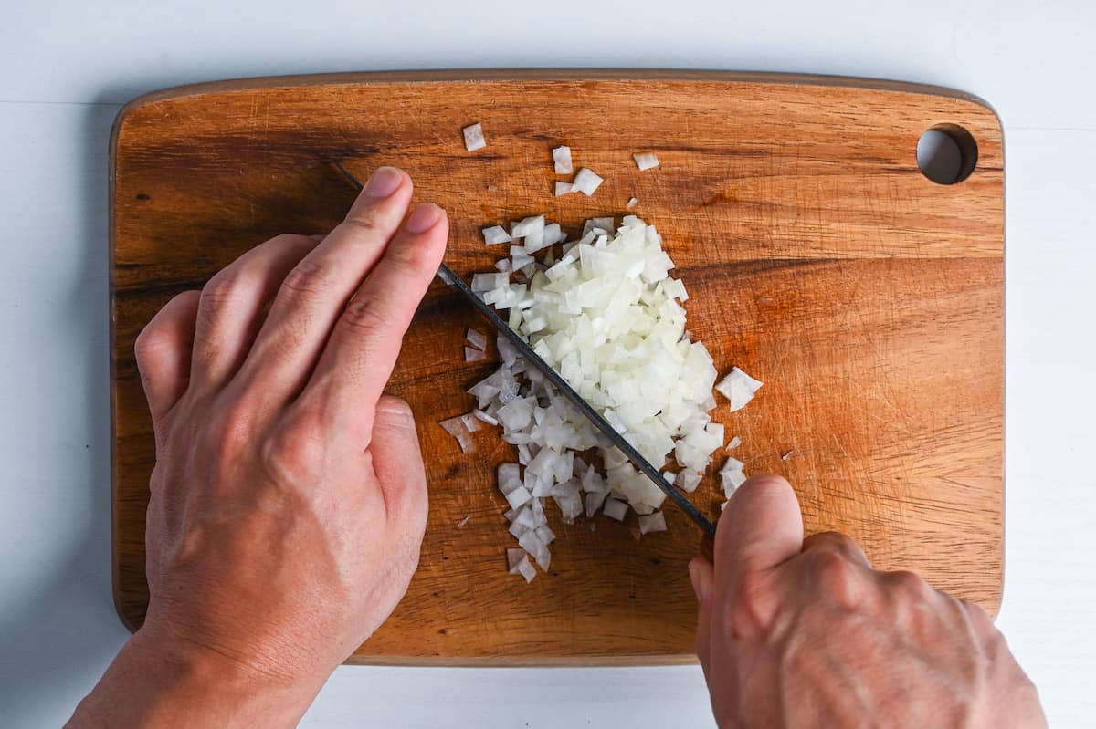 finely dicing onion on a wooden chopping board (mijingiri)