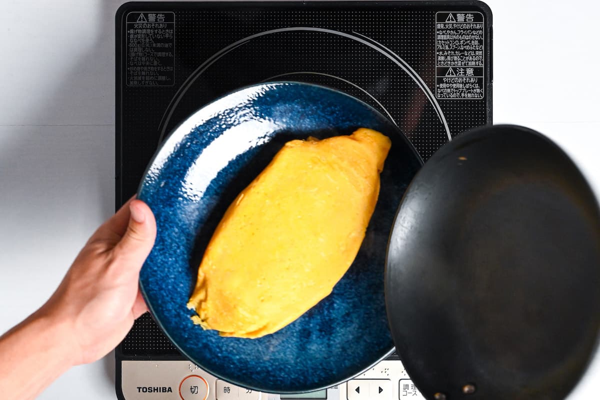 Omurice flipped onto a blue plate.