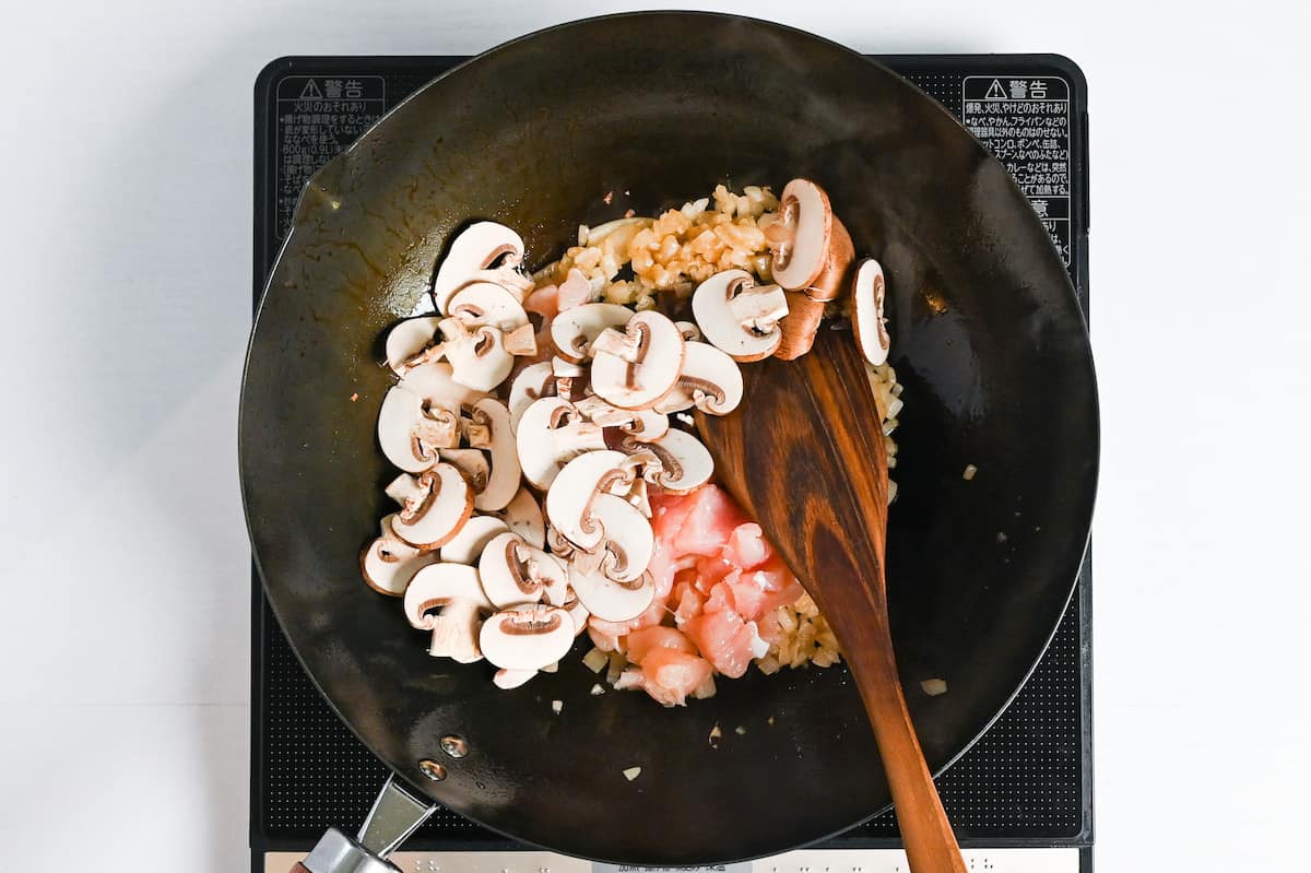 adding sliced chestnut mushrooms and cut chicken to fried onions