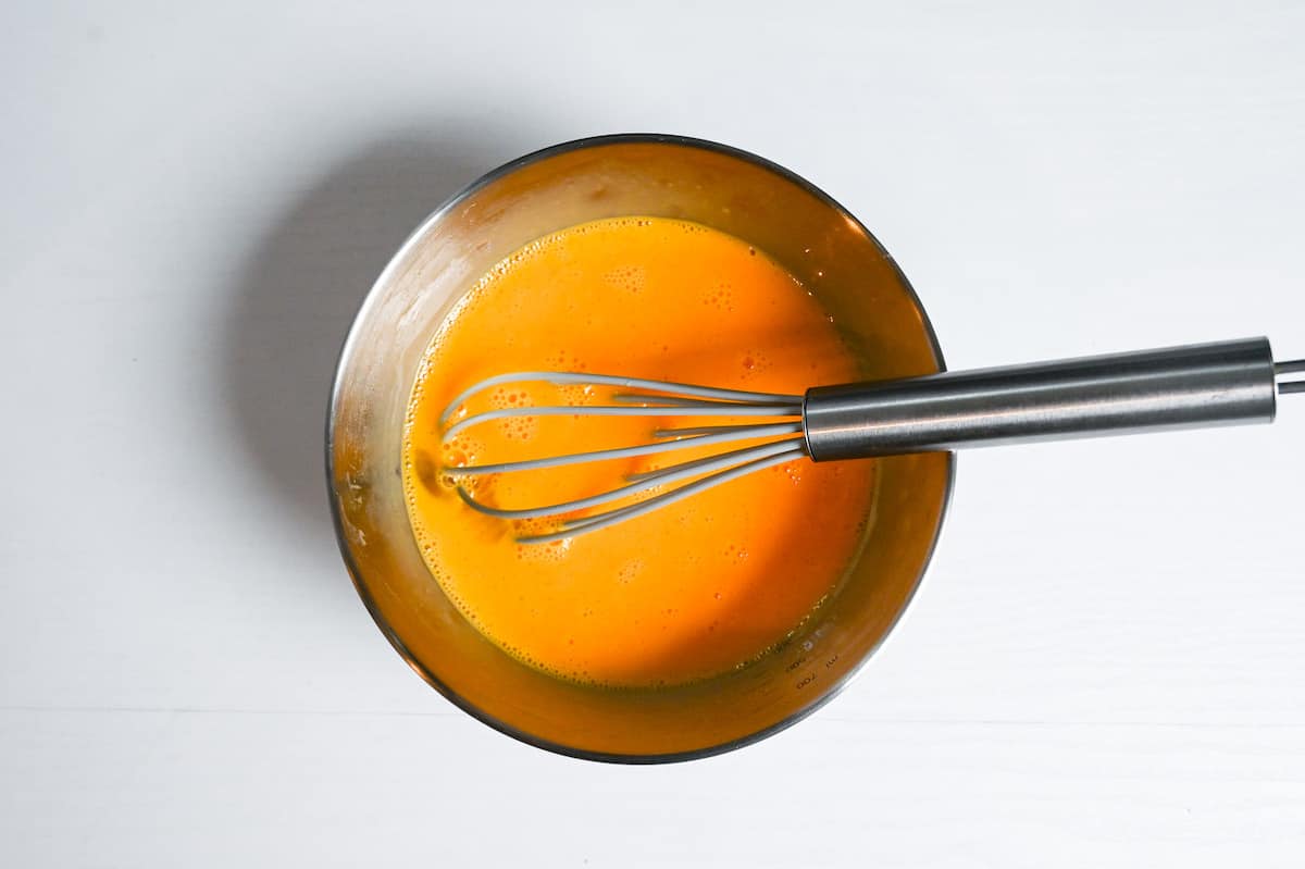 whisked egg in a metal mixing bowl