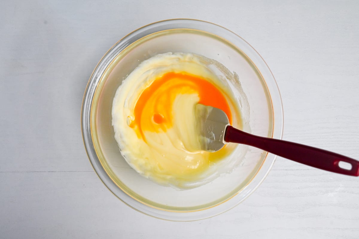 gradually adding egg to the cheesecake mixture