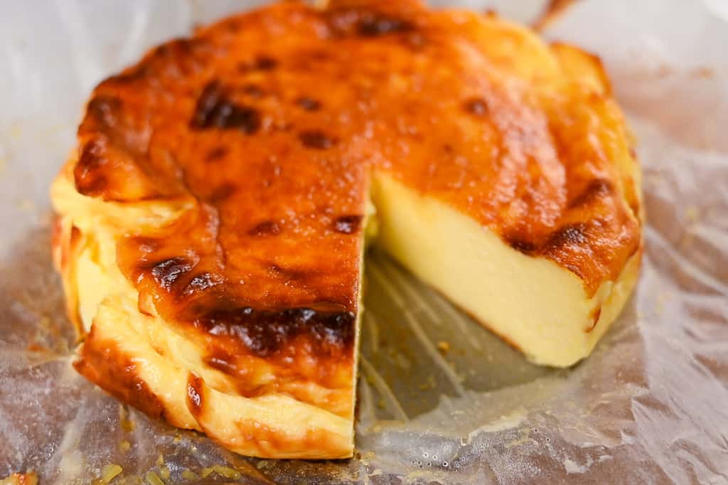 large basque cheesecake with slice missing