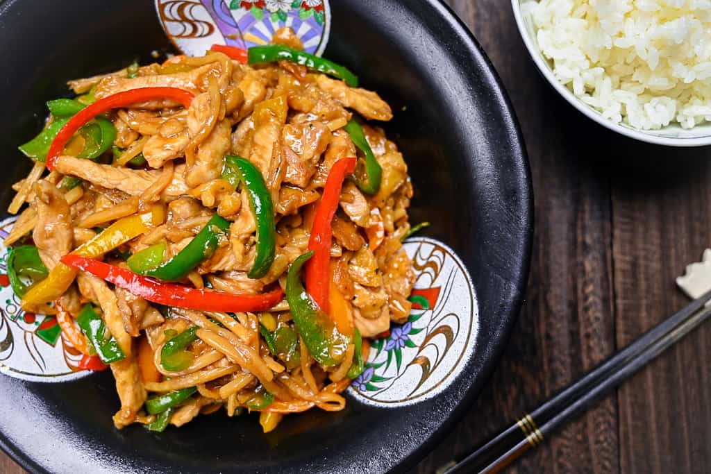 Chinjao Rosu Japanese pork and pepper stir fry served on a black plate with rice top down view