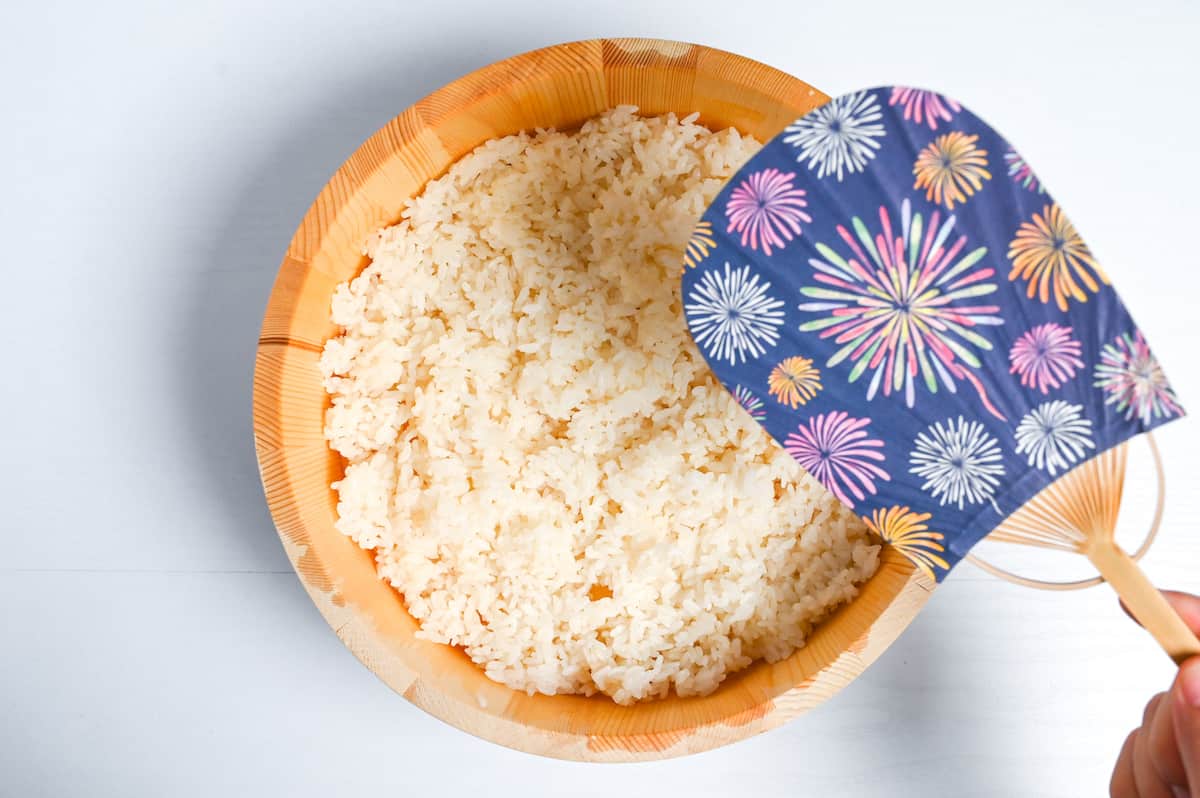 fanning rice with an "uchiwa" (Japanese flat fan)