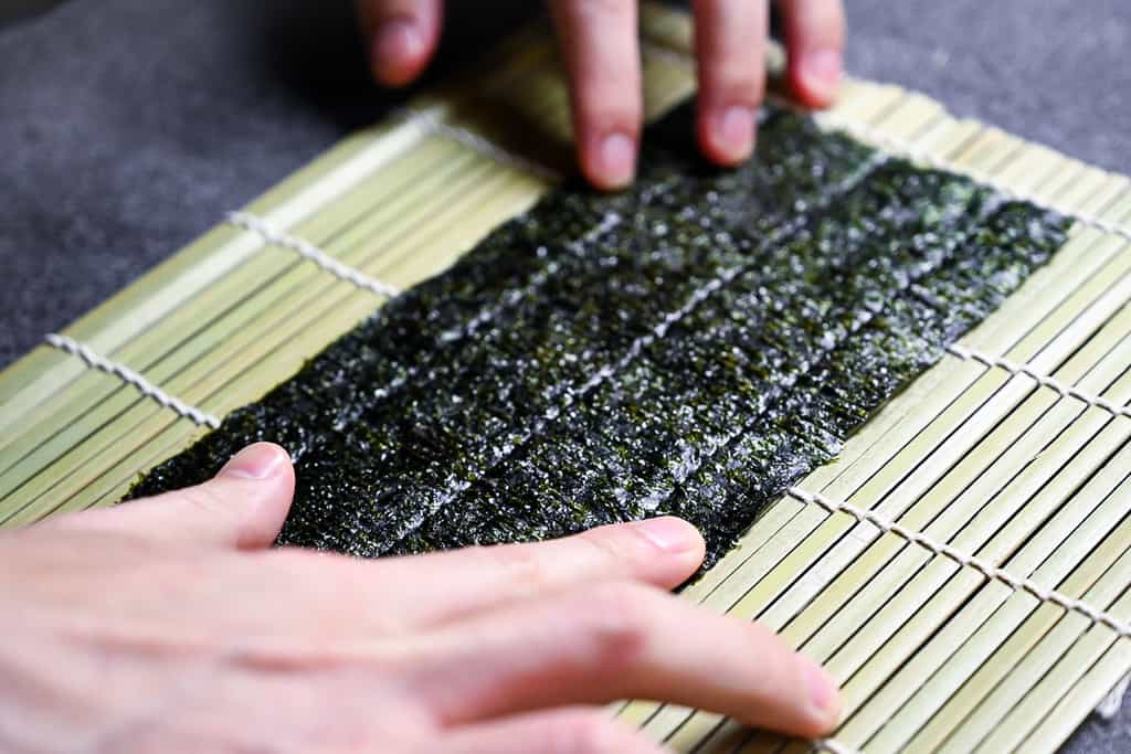 laying out the nori onto the bamboo mat