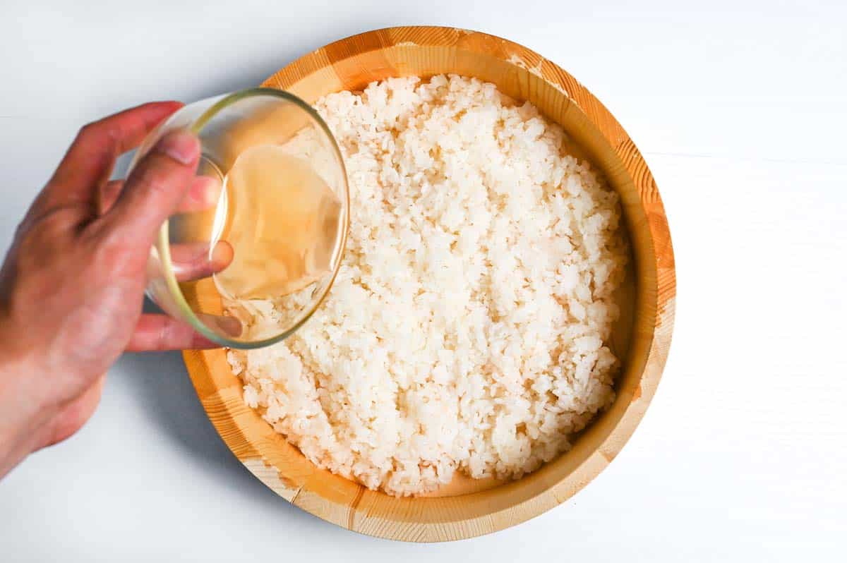 Pouring sushi vinegar mixture over warm rice