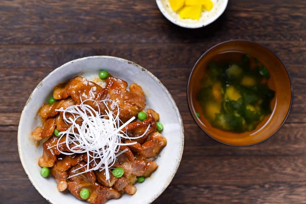 Butadon pork rice bowl served with takuan pickles and miso soup top down view