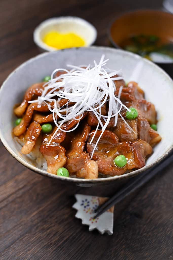 Butadon pork rice bowl served with takuan pickles and miso soup side view