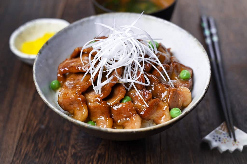 Butadon pork rice bowl served with takuan pickles and miso soup side view