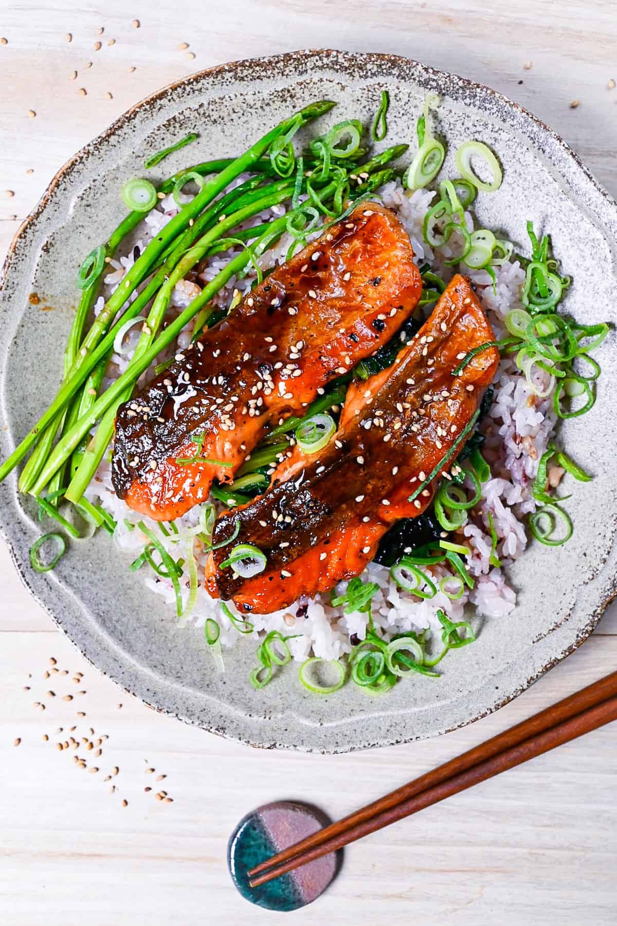 Teriyaki salmon and pan fried asparagus served over a bed a buttery spinach and mixed grain rice