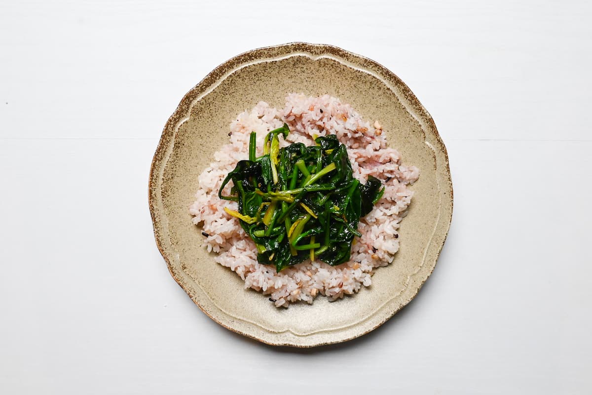 multigrain rice topped with buttery fried greens