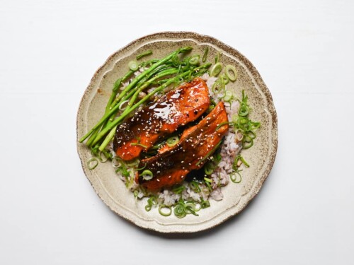 Teriyaki salmon served over multigrain rice, buttery pan fried spinach and asparagus then sprinkled with chopped spring onion and sesame seeds