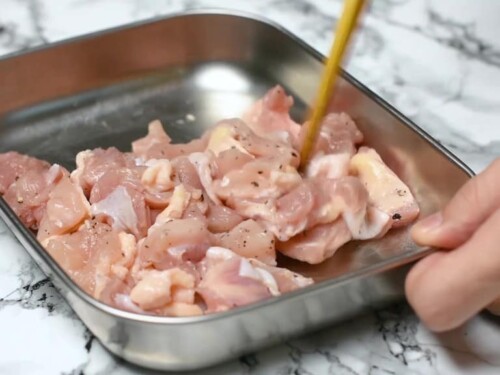sprinkling chicken thigh pieces with salt and pepper