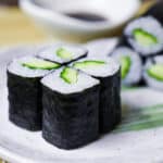 Four kappa maki sushi rolls on a plate side view