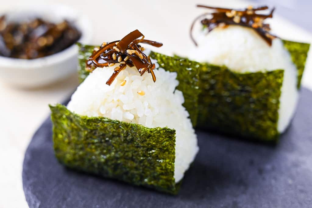 two kombu onigiri on a slate plate