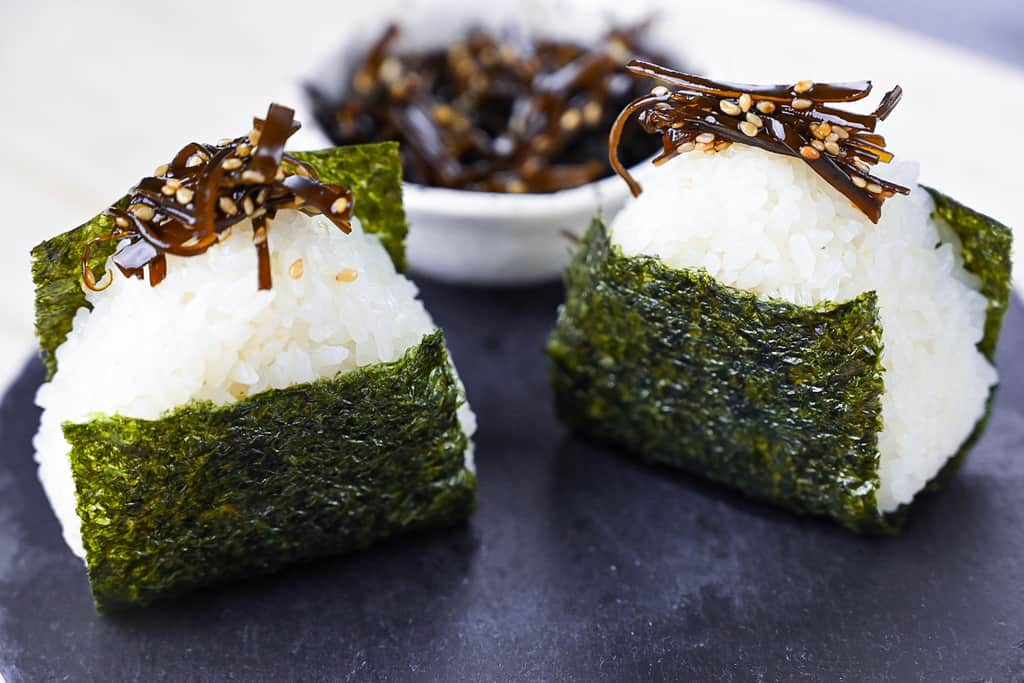 two kombu onigiri on a slate plate