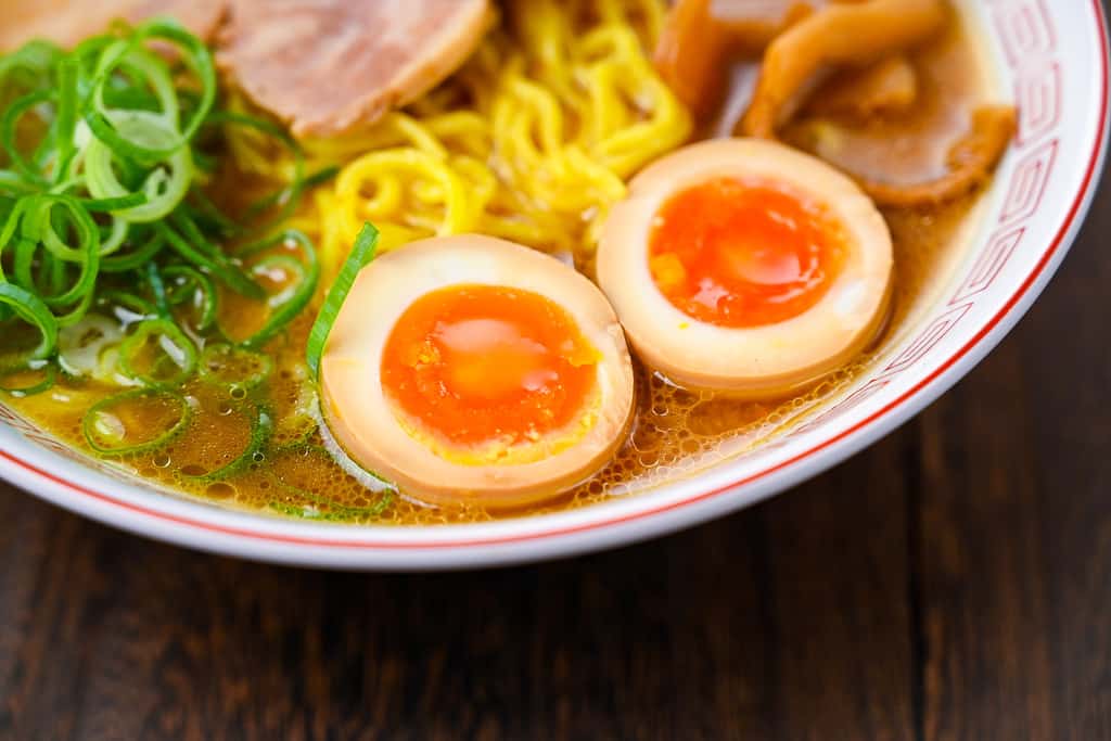 Two halves of ramen egg in a bowl of miso ramen