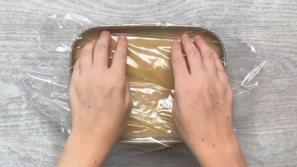 placing plastic wrap on the surface of the cooling ice cream