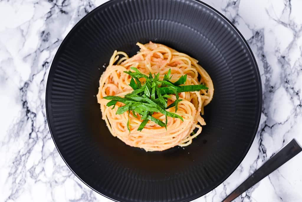 mentaiko pasta served in a black pasta dish top down