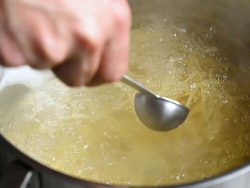 scooping pasta water