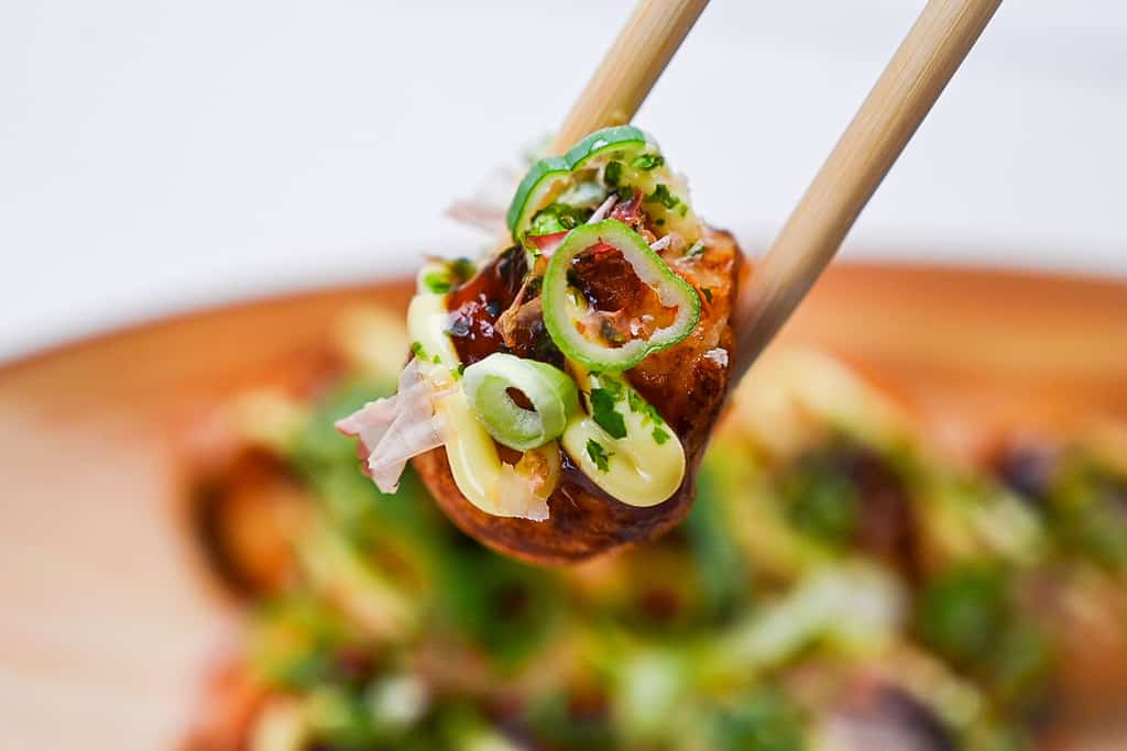 Takoyaki picked up with wooden disposable chopsticks