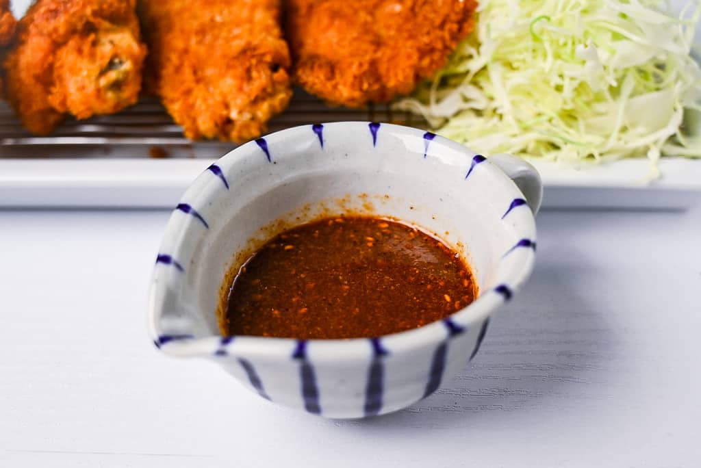Homemade katsu sauce in a small white and blue stripy jug