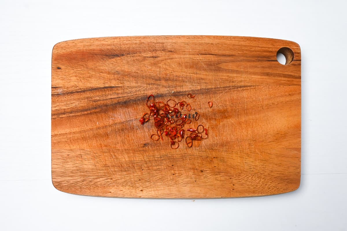 Thinly sliced dry chili on a wooden chopping board