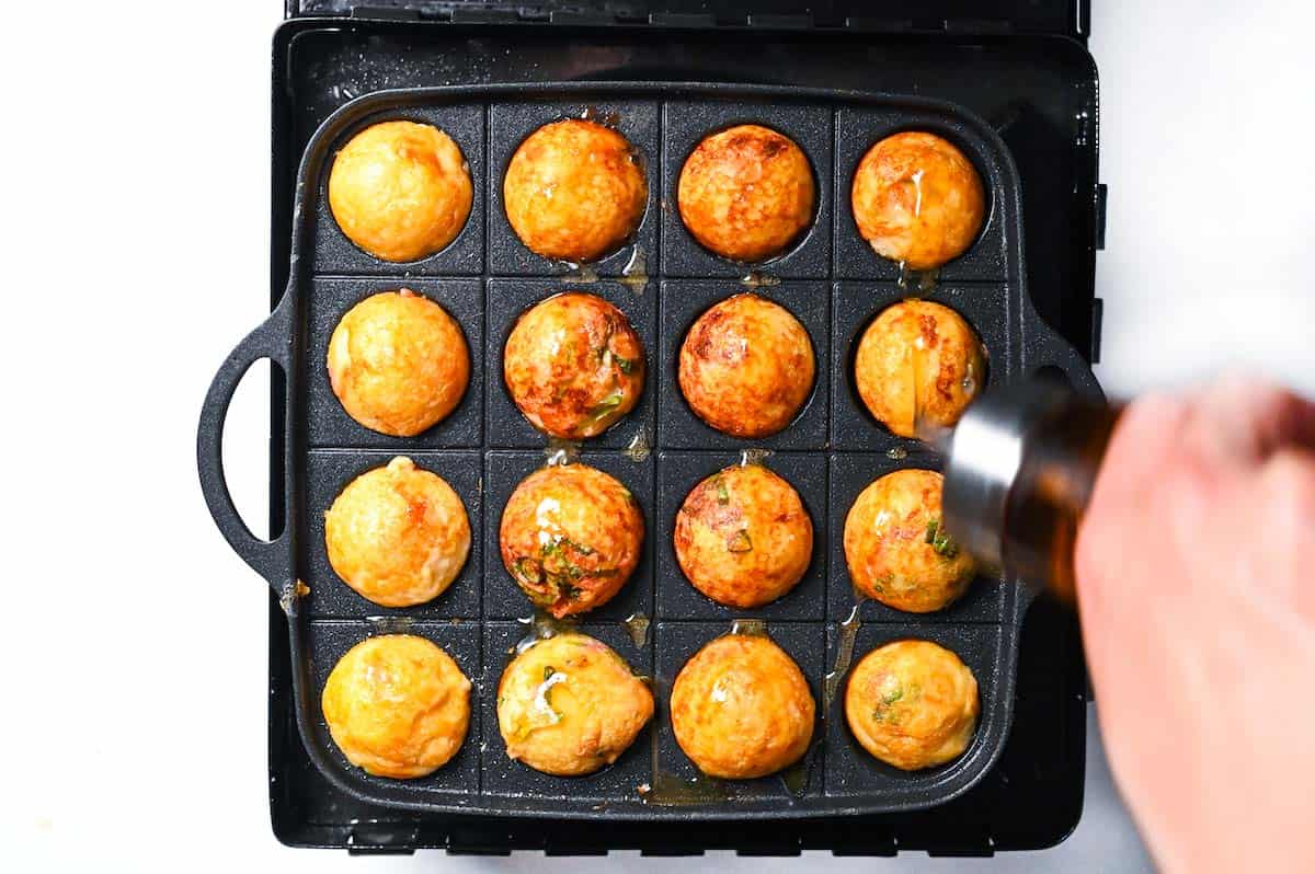 Drizzling takoyaki with sesame oil