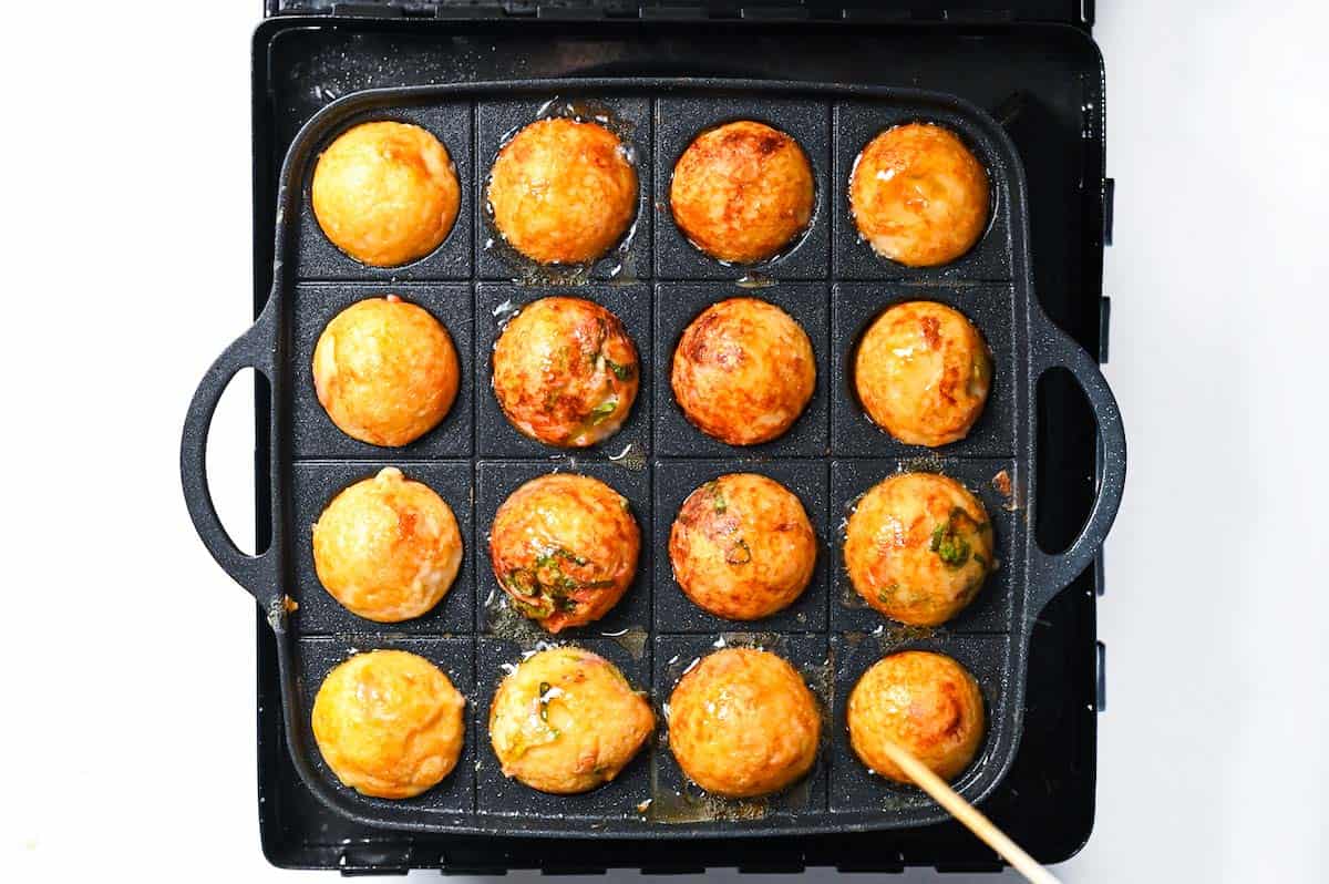 Turning the takoyaki until they're all golden