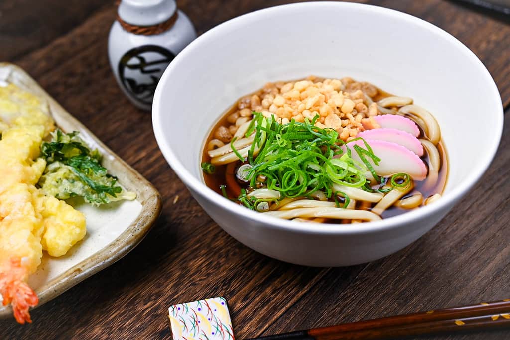 Kake udon with tempura vegetables and shichimi side view