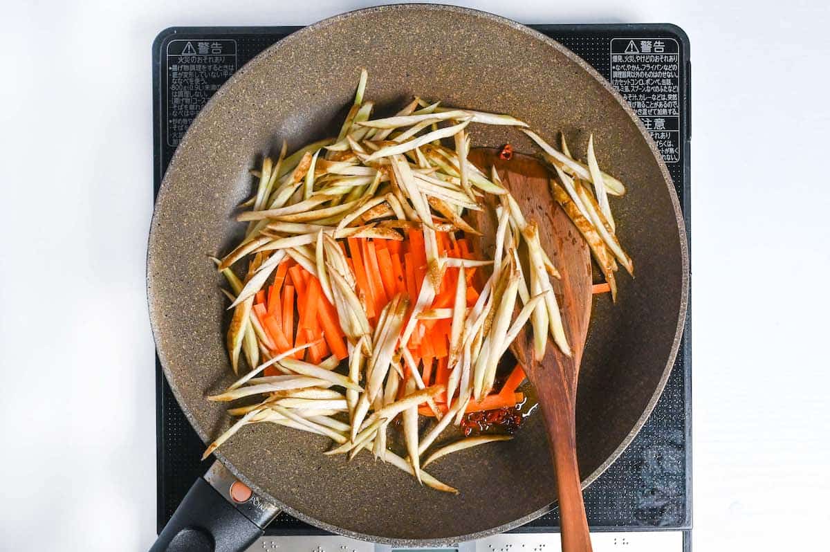 stir frying burdock root and carrot to make kinpira gobo