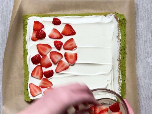 Placing strawberries on roll cake