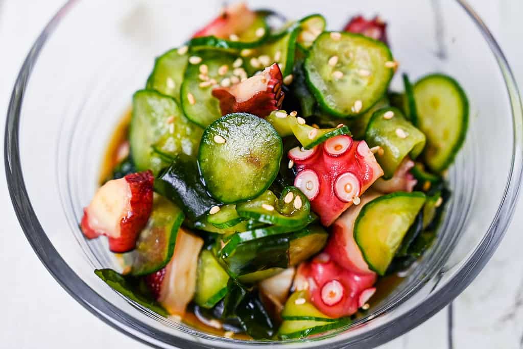 Japanese octopus and cucumber sunomono salad in a glass bowl close up