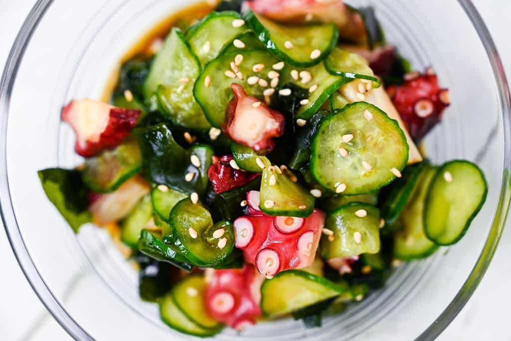 Japanese octopus and cucumber sunomono salad in a glass bowl top down closeup