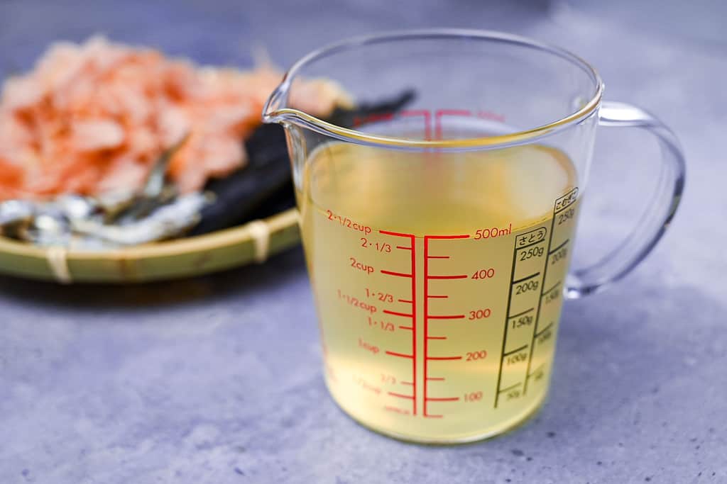 A glass jug of awase dashi made from kelp, bonito flakes and dried sardines