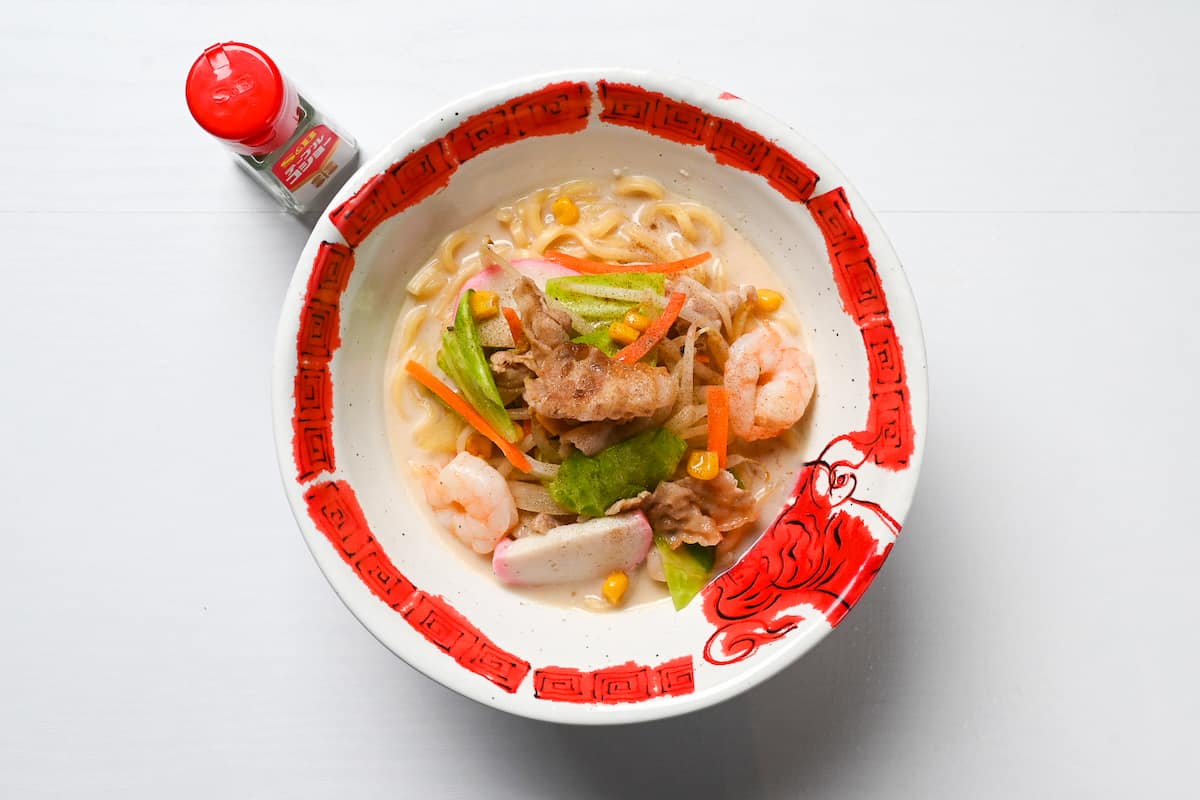 Nagasaki Champon in a red and white ramen bowl sprinkled with white pepper