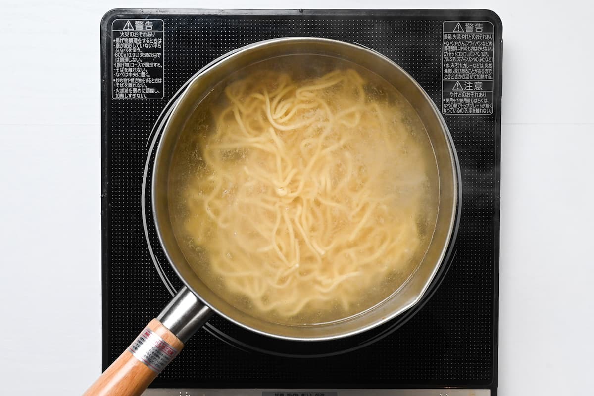 Ramen noodles cooking in a pot