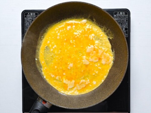 Cooking a thin egg crepe in a large frying pan