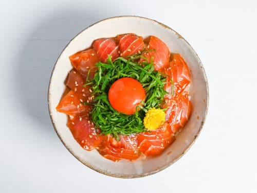 maguro zuke don (marinated tuna sashimi bowl) topped with shredded shisho, raw egg yolk