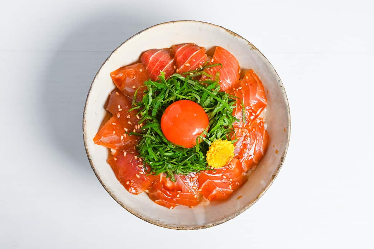 maguro zuke don (marinated tuna sashimi bowl) topped with shredded shisho, raw egg yolk